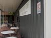 Grasshopper Cafe sign on the container wall beside the covered deck seating