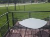 Outdoor table and chairs on the deck overlooking the campus lawn