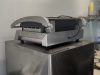Commercial contact grill on a stainless steel cabinet inside the container kitchen