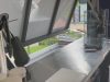 Stainless steel bench and open awning servery window inside the container kitchen