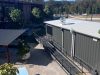 View from above of the container roof with a rooftop exhaust flue, and a long access ramp with handrails running along its side