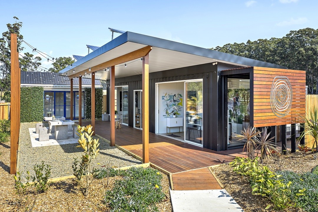 Portable shipping container sales office exterior with deck, glass and solar