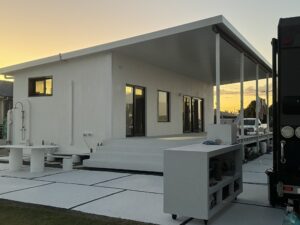 Burnett Heads granny flat at sunset — two-container clad exterior with covered deck and outdoor living